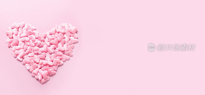 粉色浪漫的心在粉色之上。垂直问候情人节卡片。