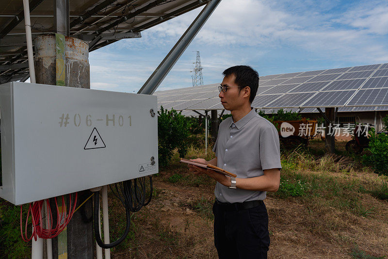 男工程师正在检查太阳能电池板的光伏合流箱