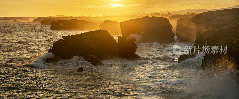 海滩——巨大的海浪在日出时撞击岩石峭壁