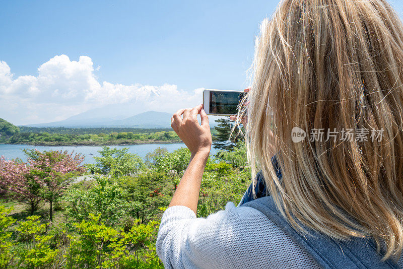 一名女子在日本旅行，她用手机拍了一张照片