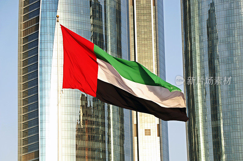 阿拉伯联合酋长国(uae)的国旗在阿布扎比的高楼前飘扬