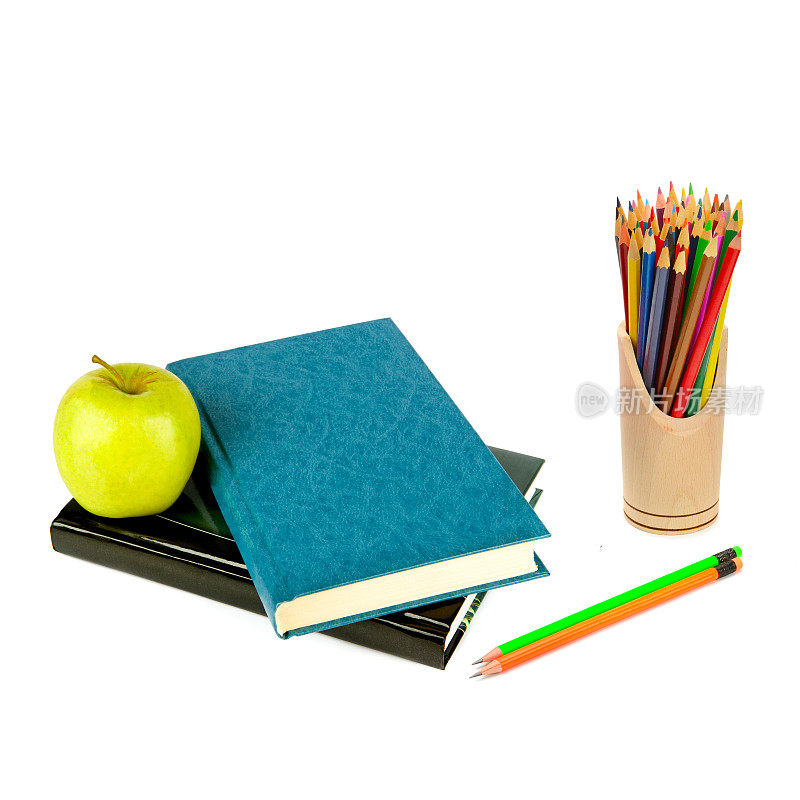 书籍、苹果和彩色铅笔被隔离在白色的背景上。