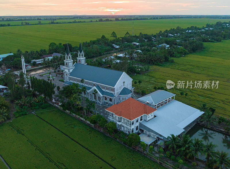 这座教堂坐落在夕阳西下的绿色稻田中，江省