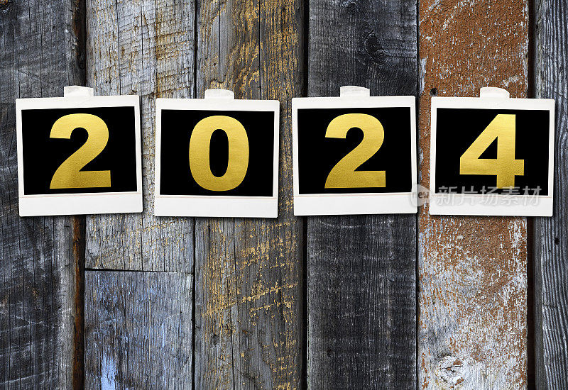 一排2024年新年的照片贴在旧木墙上
