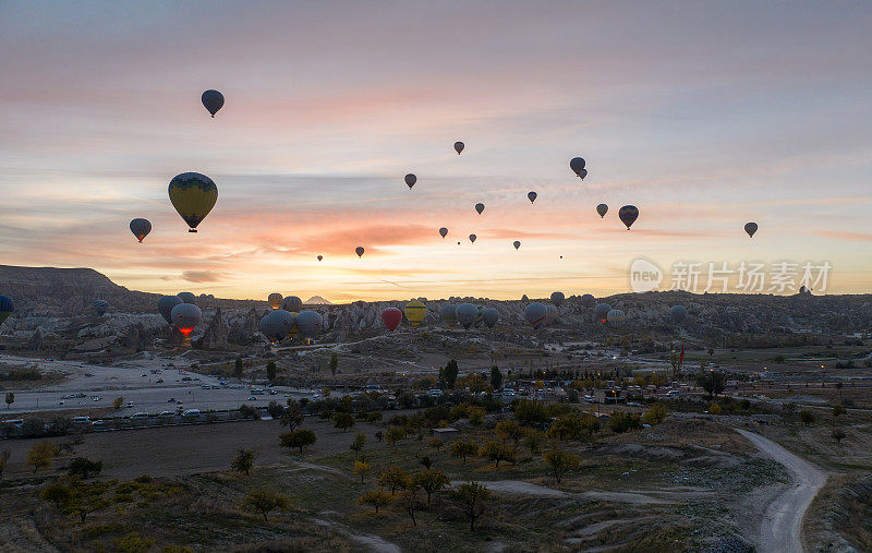 在土耳其卡帕多西亚的岩石景观上空飞行的热气球。