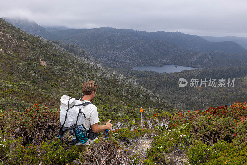 耐力之旅:男子徒步旅行与暴风雨的天空在长途跋涉