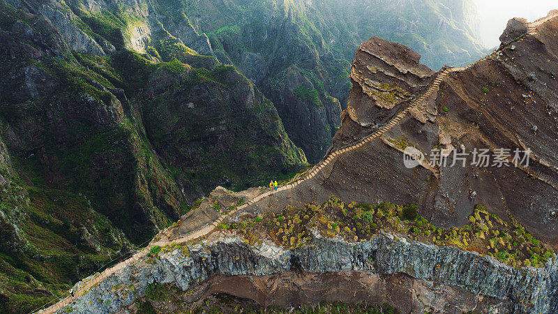 鸟瞰女人和男人在楼梯上徒步旅行在戏剧性的极端山区地形马德拉岛