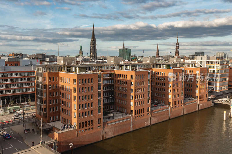 汉堡港城区的Speicherstadt。德国风景，德国旅行摄影。易北河与商业码头的照片。夕阳和天空，傍晚的好天气。港口的船只和建筑。