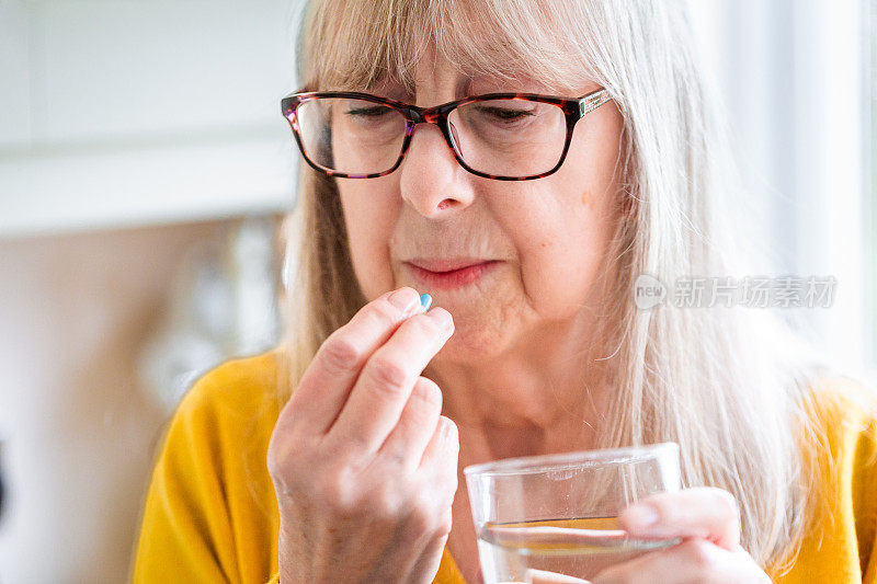 一位老年妇女正在服用药物