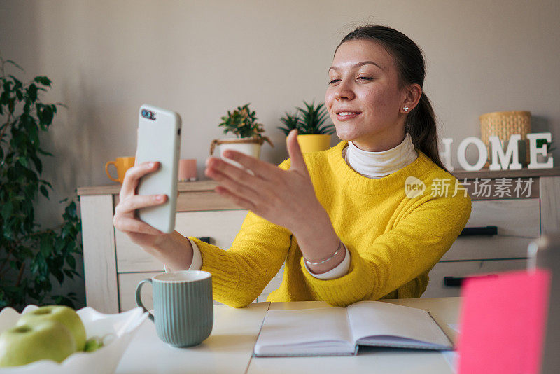 一个年轻的女孩正在进行视频通话。他用智能手机给我发了一个吻。