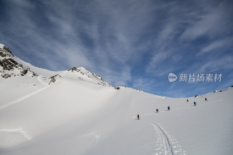 滑雪登山运动员攀登白雪皑皑的山峰