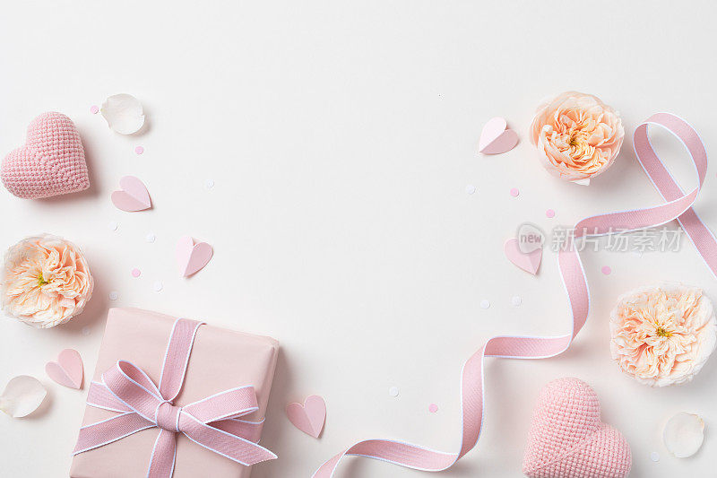 生日、女性或母亲节贺卡。粉红色的心，玫瑰花和礼盒在桌面视图。平的。