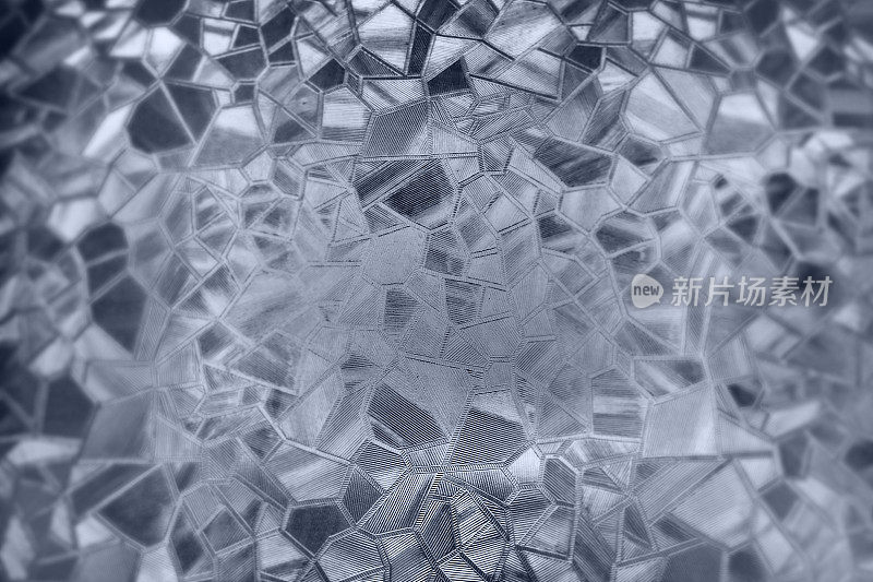 压花玻璃背景。波纹玻璃单色。背光下凹凸不平的透明表面的光折射。白色和灰色的发挥凸显。黑色区域。抽象的背景。