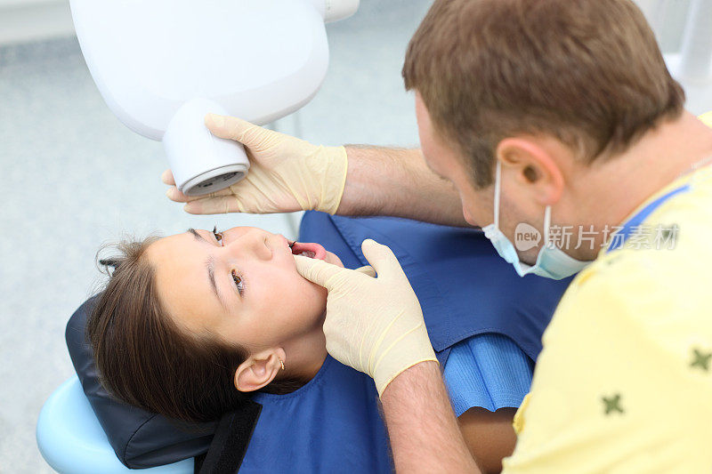 牙医准备为女孩做牙齿x光成像