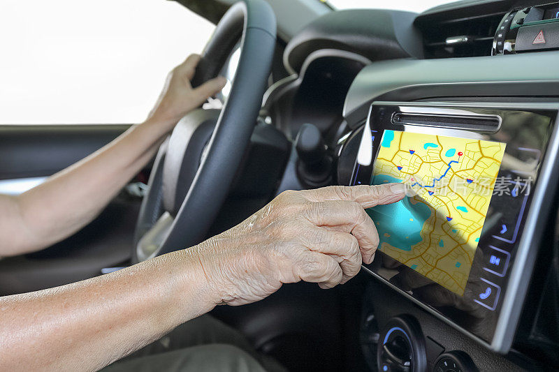 老妇人在车里使用GPS导航系统