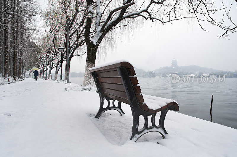 中国杭州，西湖岸边白雪覆盖的长凳