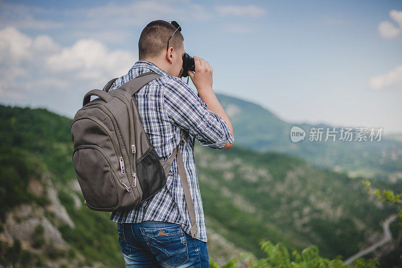 一个背着背包的年轻人正在拍照