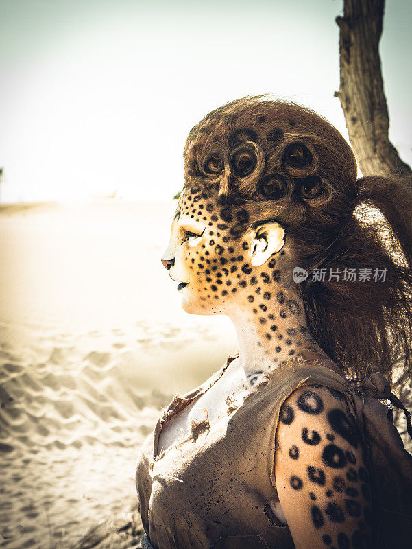 模特穿着猎豹化妆摆姿势的沙漠