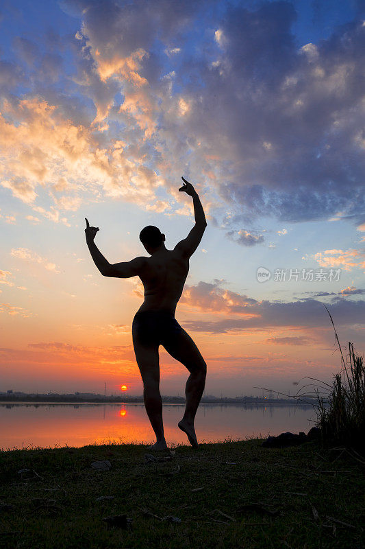 印度古典舞蹈演员的剪影在夕阳中摆姿势。