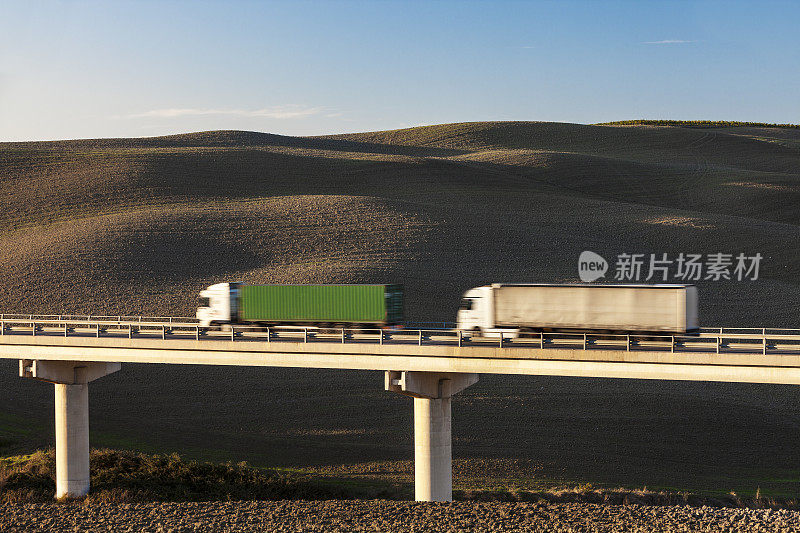 两辆卡车行驶在意大利托斯卡纳的高速大桥上