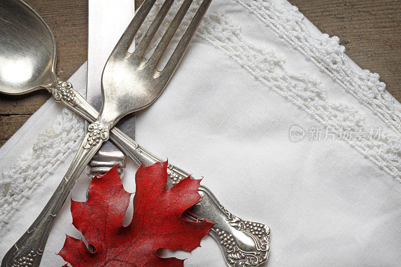 感恩节地点设置在亚麻餐巾和红色的落叶