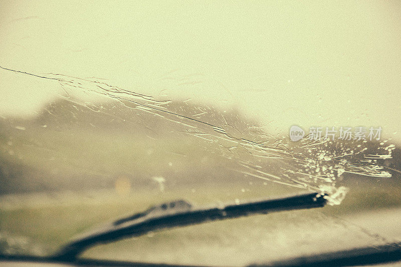 在一个非常下雨的日子里，在新布伦瑞克的道路上驾驶的一个挡风玻璃刮水器的特写。