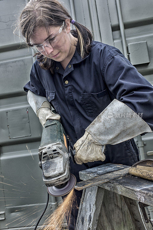 年轻女性建筑工人与磨床。