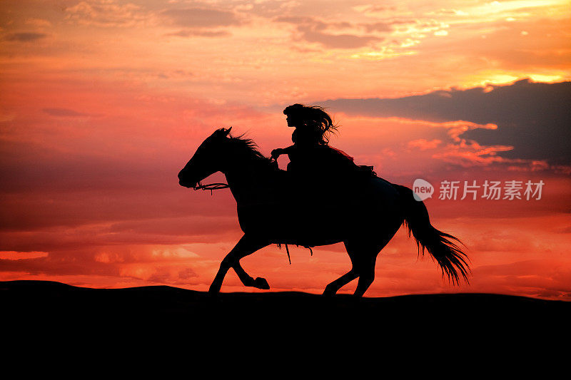 剪影女孩与长发骑在奔跑的马在日落