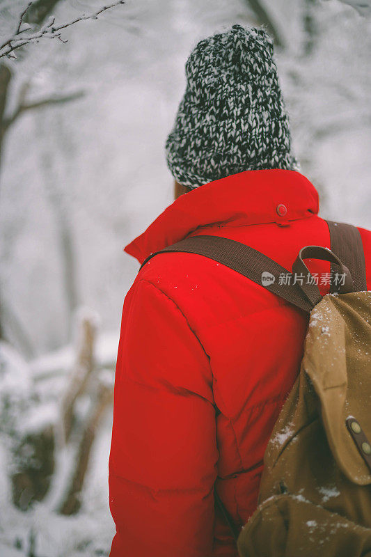 冬季运动活动。女徒步旅行者背包和雪鞋在雪地上的雪鞋