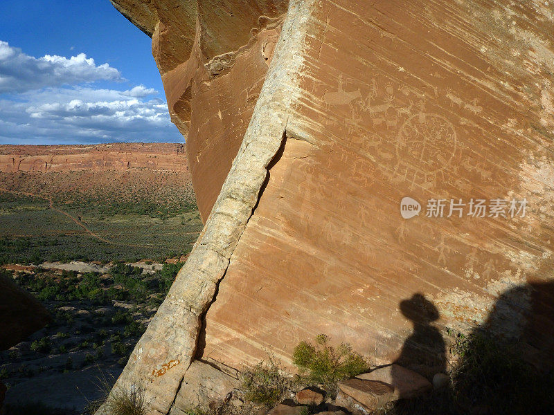 徒步旅行者的影子欣赏古老的尤特人和普韦布洛人的岩石雕刻犹他州