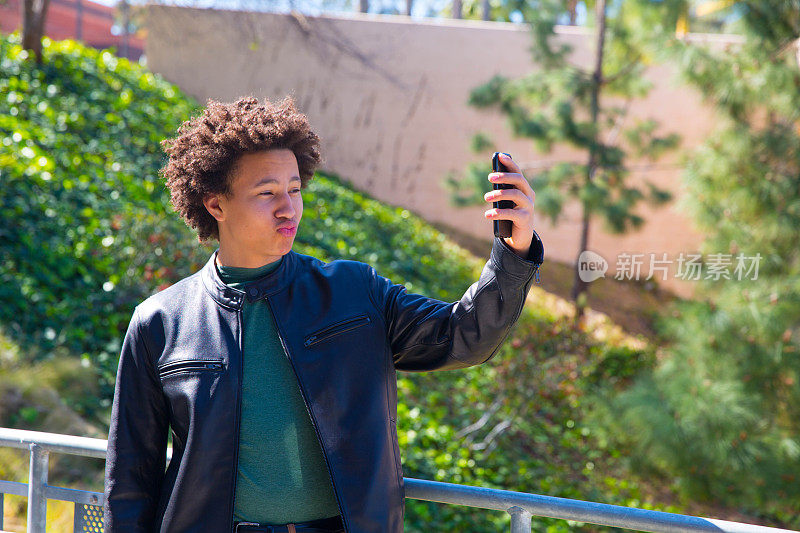 非裔美国青少年用手机自拍做滑稽的鸭子脸