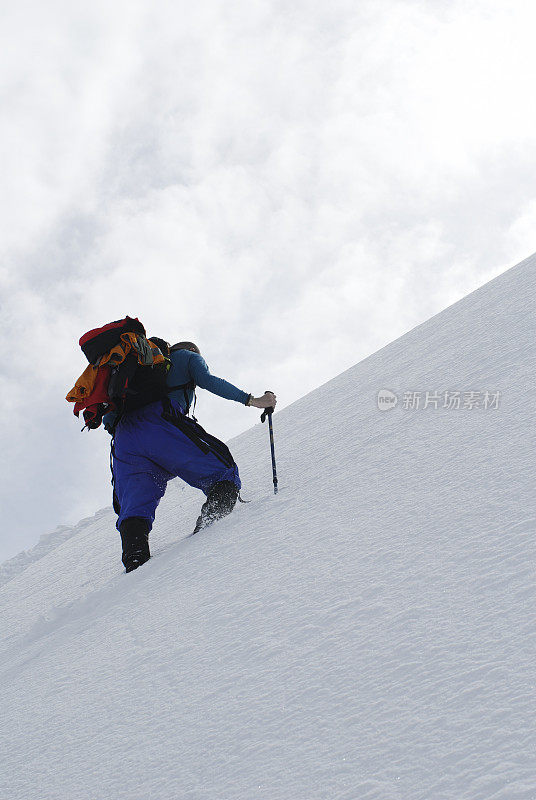 在新雪中攀登顶峰的登山者