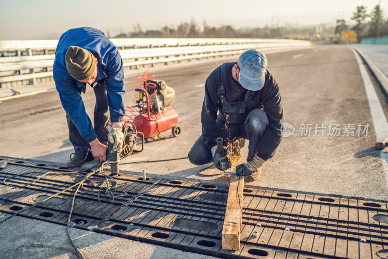 两个建筑工人正在修路。