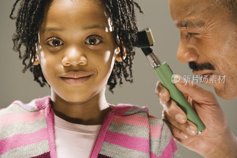 医生检查小女孩(8-9岁)，耳镜检查
