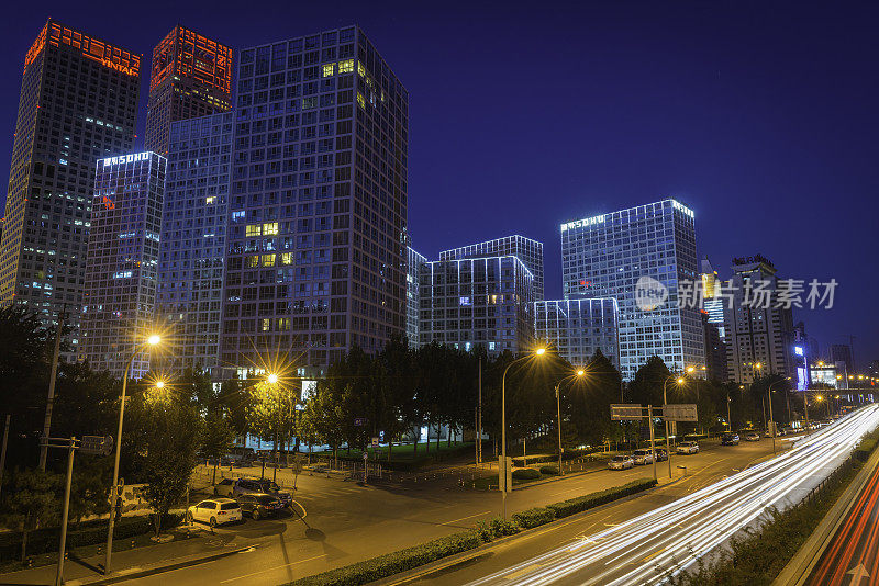 在中国的北京，霓虹灯照亮了夜晚的摩天大楼和疾驰的交通