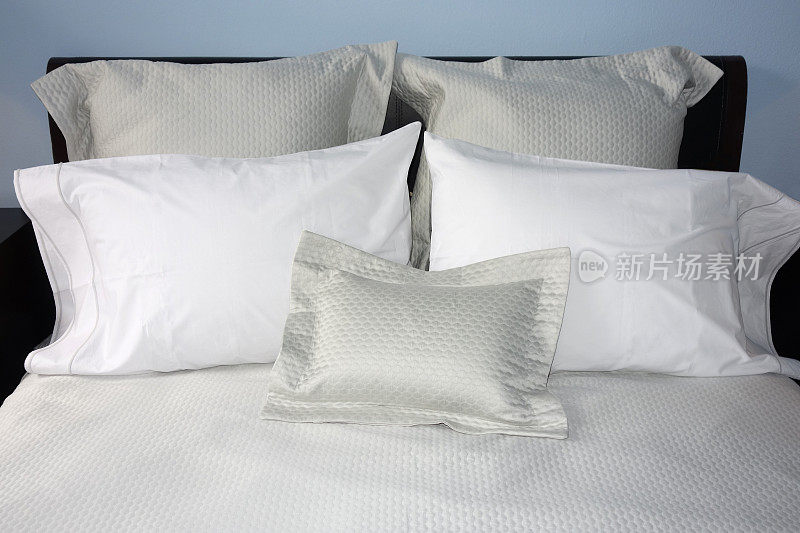 床上有银灰色和白色的枕头