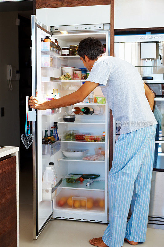 饥饿:成熟的男人打开冰箱门
