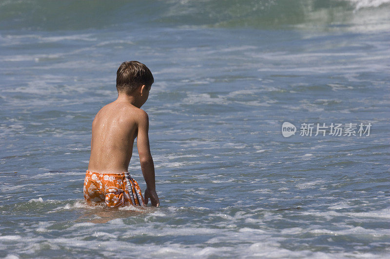 小男孩在海浪中嬉戏，享受夏日海滩日