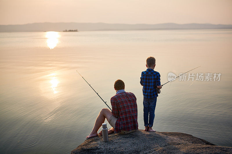 父亲和儿子在日落钓鱼
