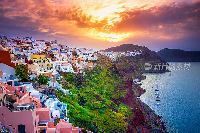 希腊圣托里尼岛伊亚镇令人惊叹的日出。位于爱琴海火山口的传统和著名的蓝色圆顶房屋和教堂