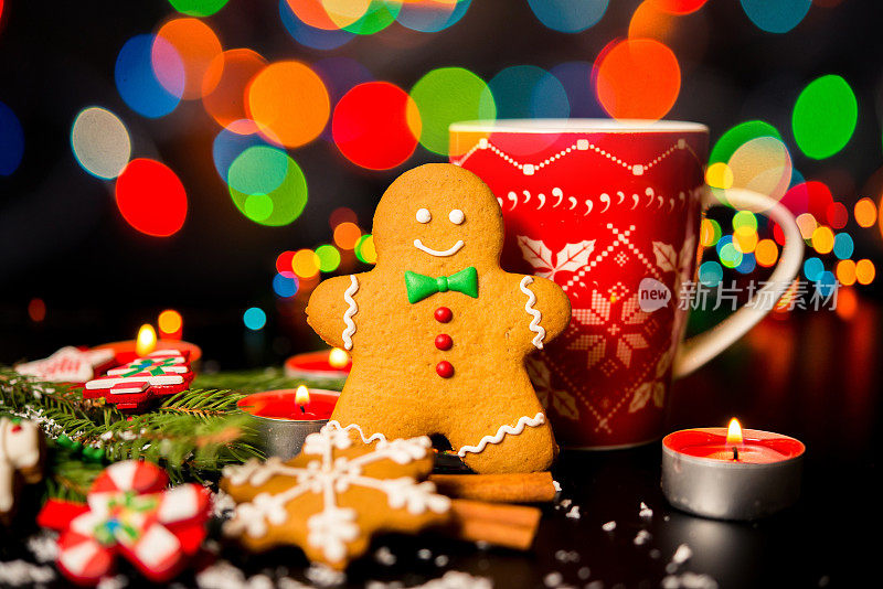 圣诞卡片-姜饼人姜饼，圣诞装饰，雪，蜡烛，杯与可可，茶或咖啡和圣诞灯