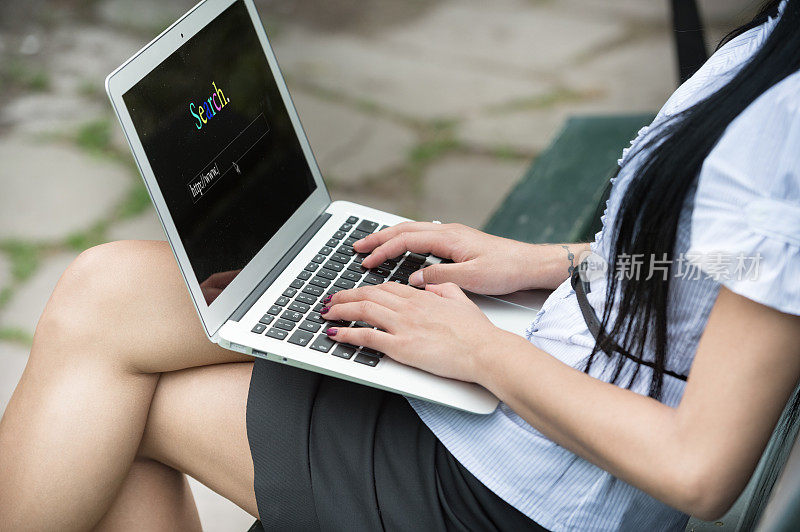 年轻的亚洲女程序员工作，远程办公，在绿色公园