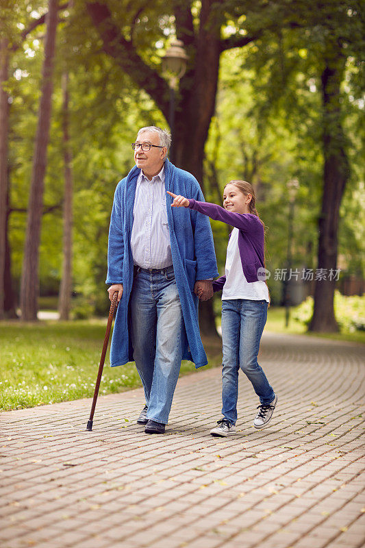 孙女在公园里展示东西残疾的爷爷