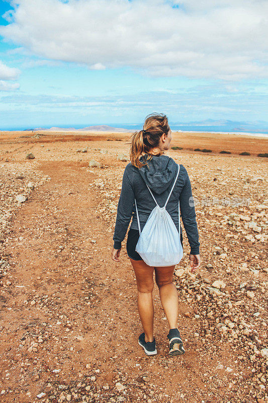 年轻女子徒步旅行与全景火山