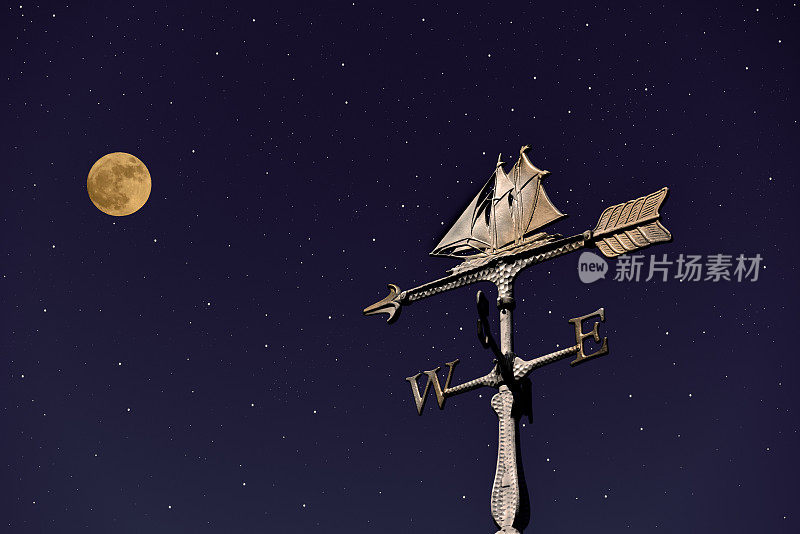 满月和星星在帆船风向标上升起。
