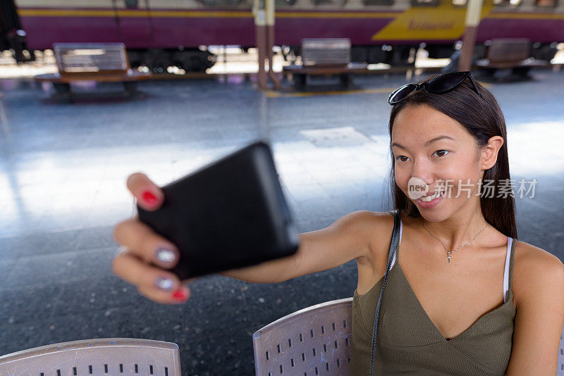 年轻美丽的多民族女游客的肖像在火车站华兰芳在泰国曼谷