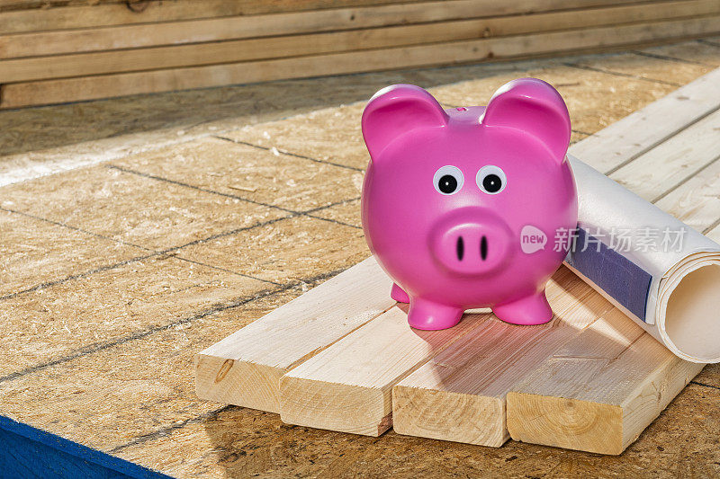 粉色存钱罐，里面有建筑工地上的木材和蓝图，概念房屋净值贷款。