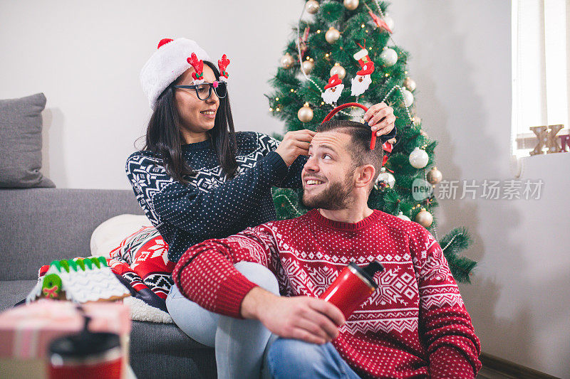 快乐的夫妇装饰圣诞树。