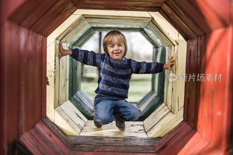 微笑的小男孩在户外操场玩。