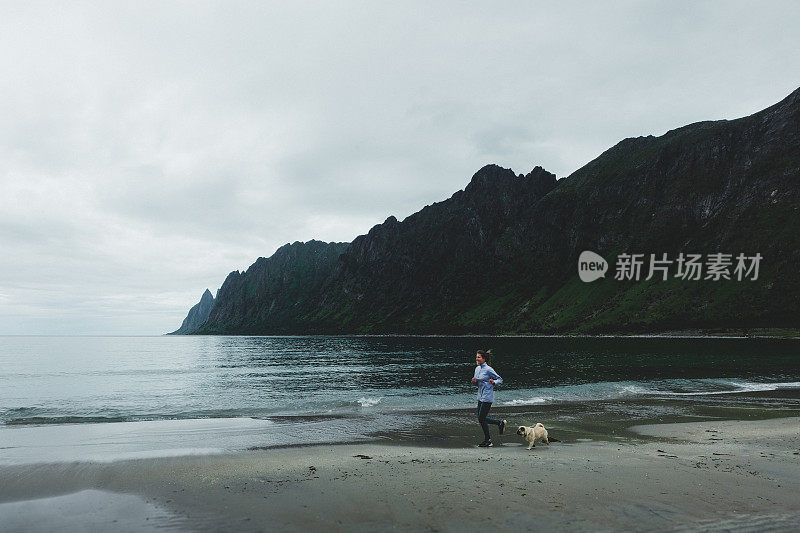 在挪威，一个女人带着狗在雨中奔跑